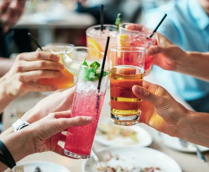 Group of people toasting drinks of various colors above table at Ocean City Fontainebleau Resort in Ocean City, MD