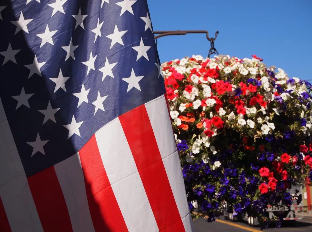 American Flag hanging next to flower pot of red white and blue flowers at Ocean City Fontainebleau Resort in Ocean City, MD